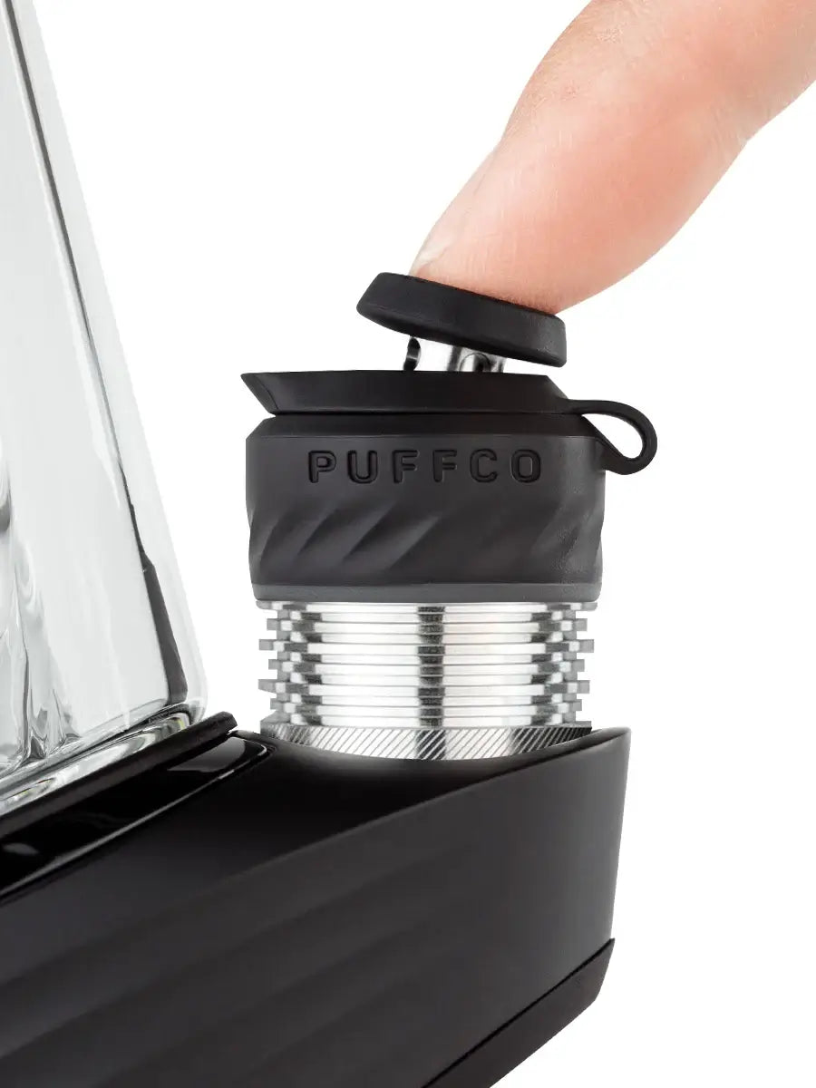 Close-up of Puffco Peak Pro with a finger pressing the cap for optimized concentrate delivery.