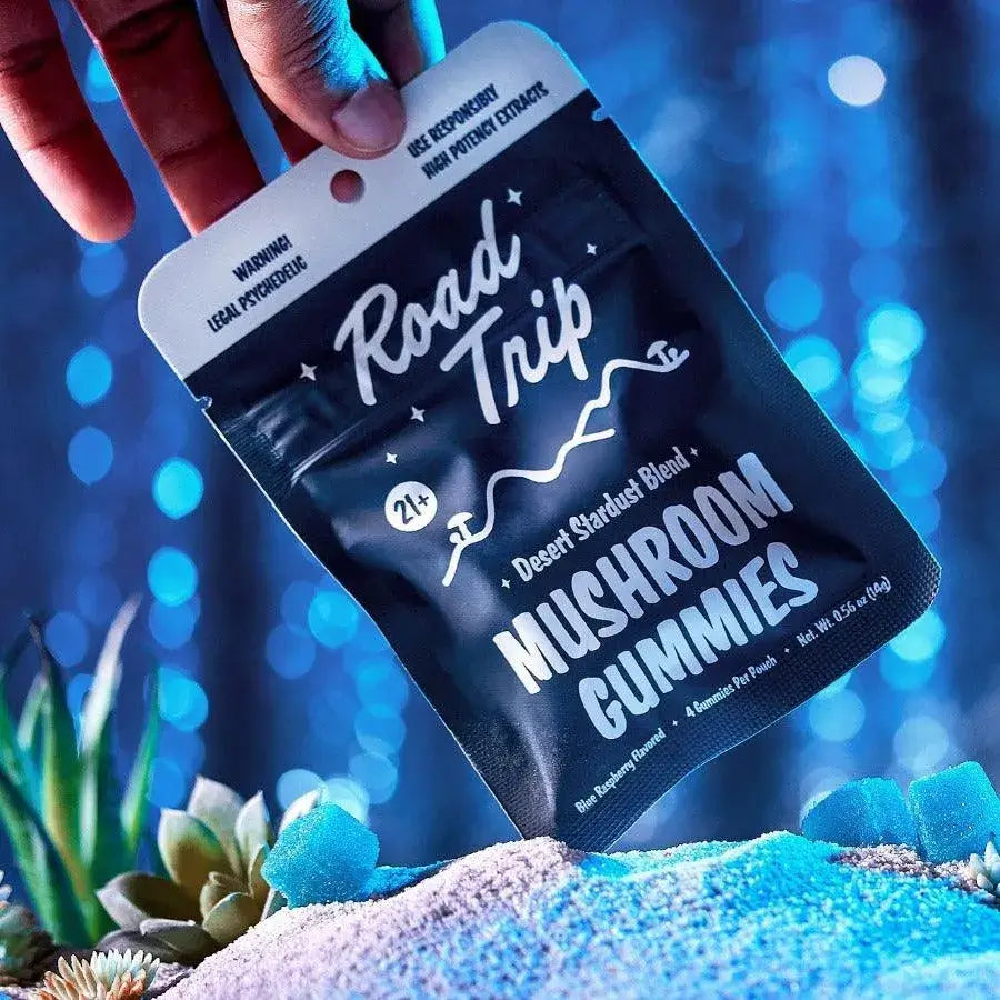 Road Trip Mushroom Gummies packaging featuring bold graphics and blue raspberry flavor, on a vibrant background with plants.